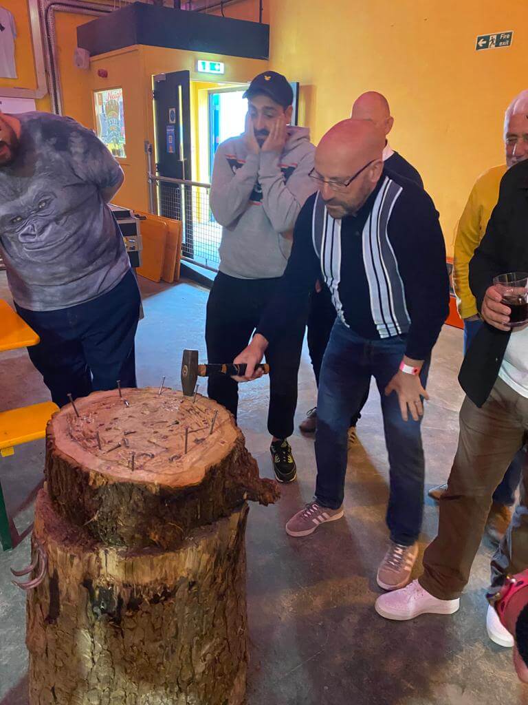 The warm-up picture of the lodge members practising getting their eye hand co ordination, hitting nails into the wood