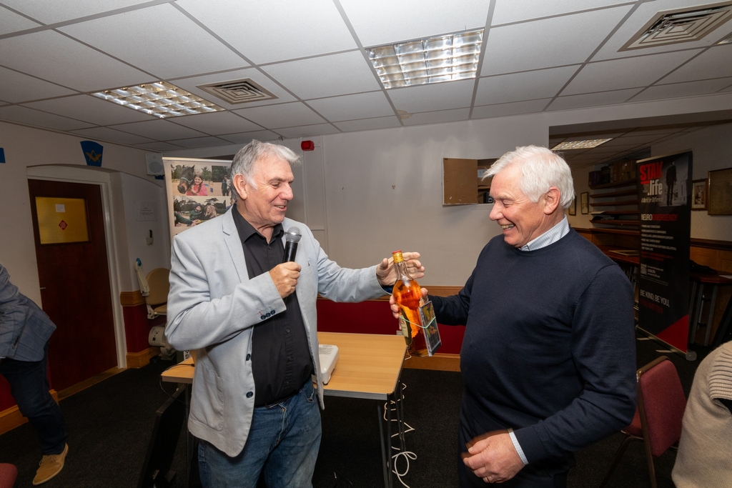 Miki Travis presents the winner of the heads and tails with his prize Miki Travis presents the winner of the heads and tails with his prize